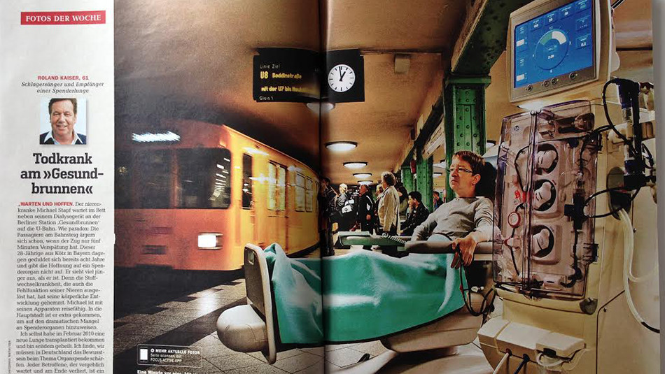 Pages of a magazine showing a person on a hospital bed in a train station