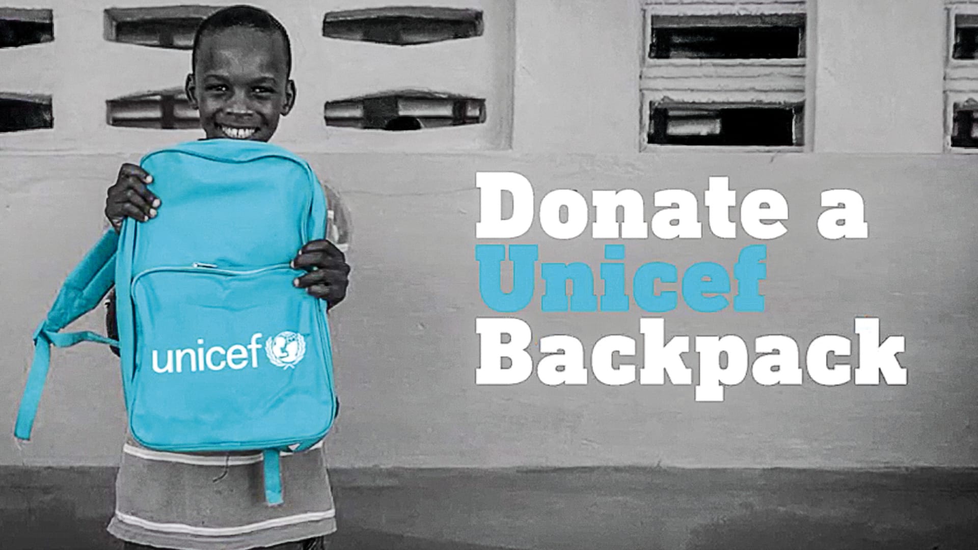 A child holding a Unicef backpack